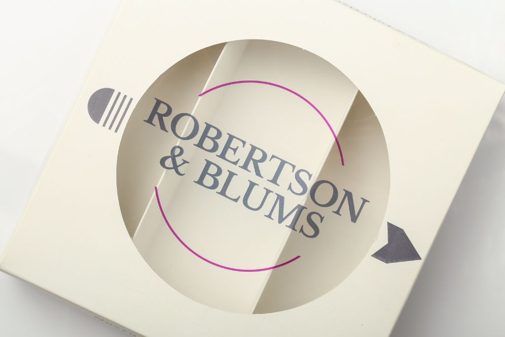 Robertson & Blums — white box, top view, circular die-cut window with logo