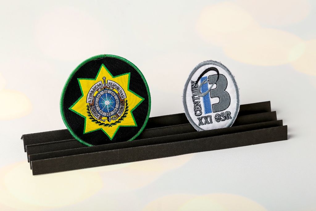 Embroidered patches — Azərbaycan Respublikası (round, black-green-yellow, MIA emblem) and Century XXI Əsr (oval, grey-white, machine embroidery)