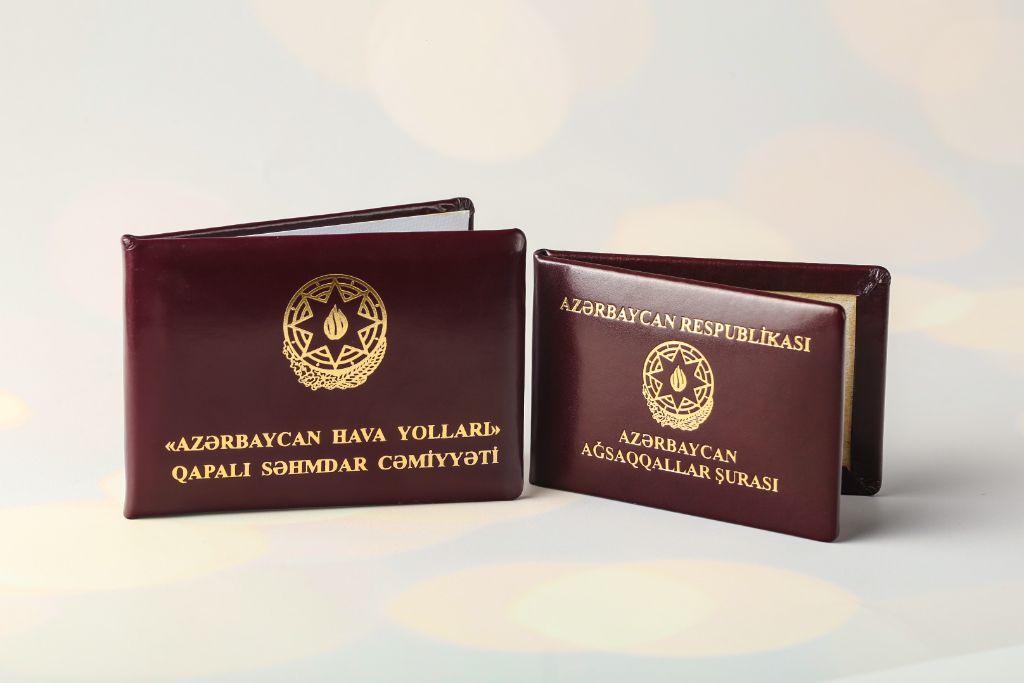 ID booklets — Azerbaijan Hava Yolları and Azərbaycan Ağsaqqallar Şurası, burgundy leather, gold embossing, coat of arms of Azerbaijan