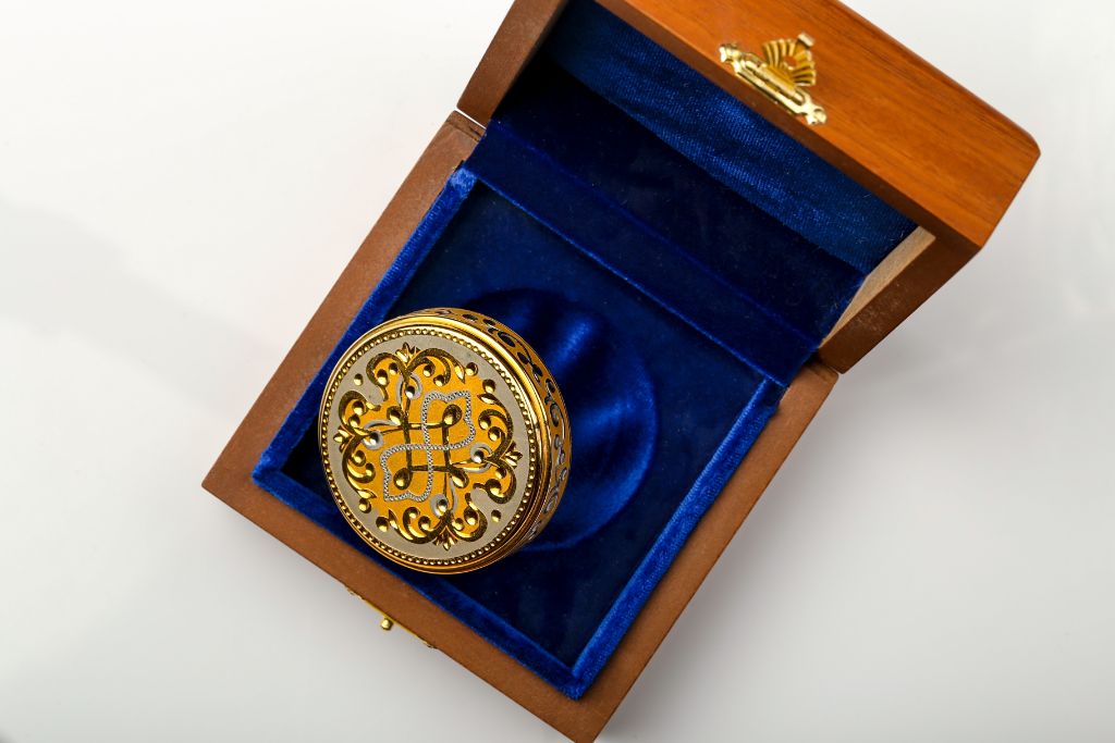 Round VIP stamp with arabesque ornament in blue velvet casket — top view