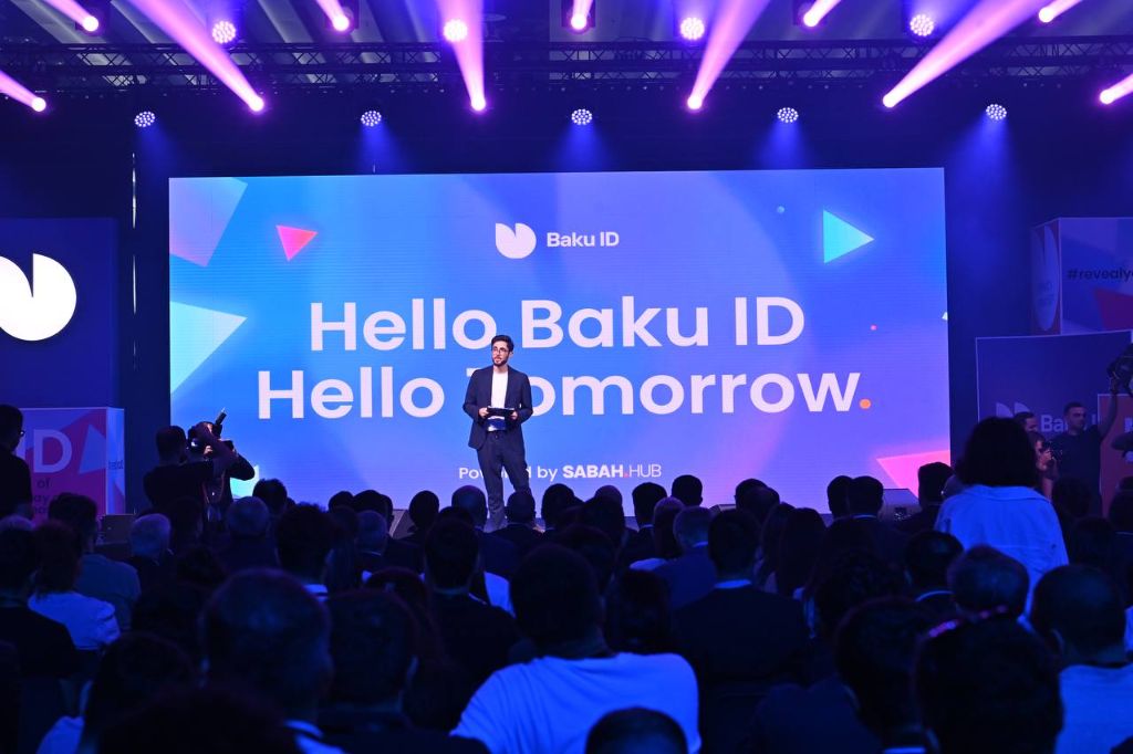 Baku ID 2024 — presenter on stage with LED wall showing Hello Baku ID Hello Tomorrow