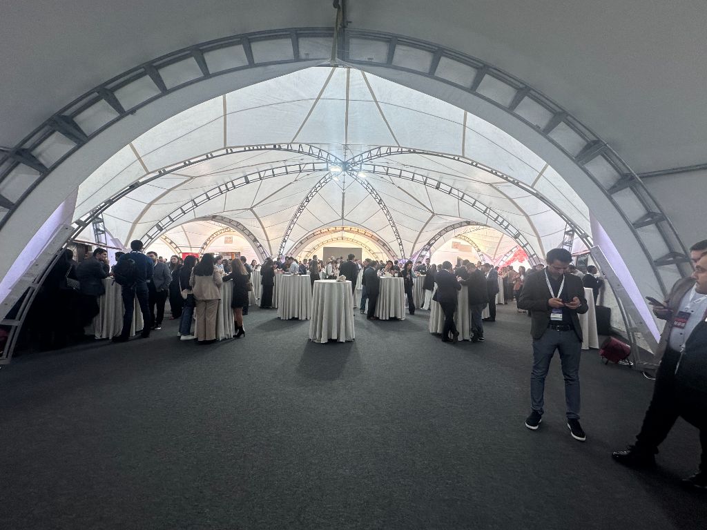 INMerge 2024 dome networking zone panoramic — full crowd, cocktail tables, truss rig