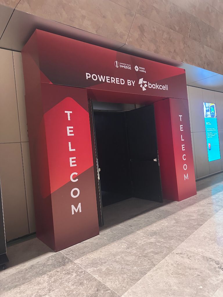 INMerge 2024 TELECOM stage branded entrance arch — Bakcell powered, red branding