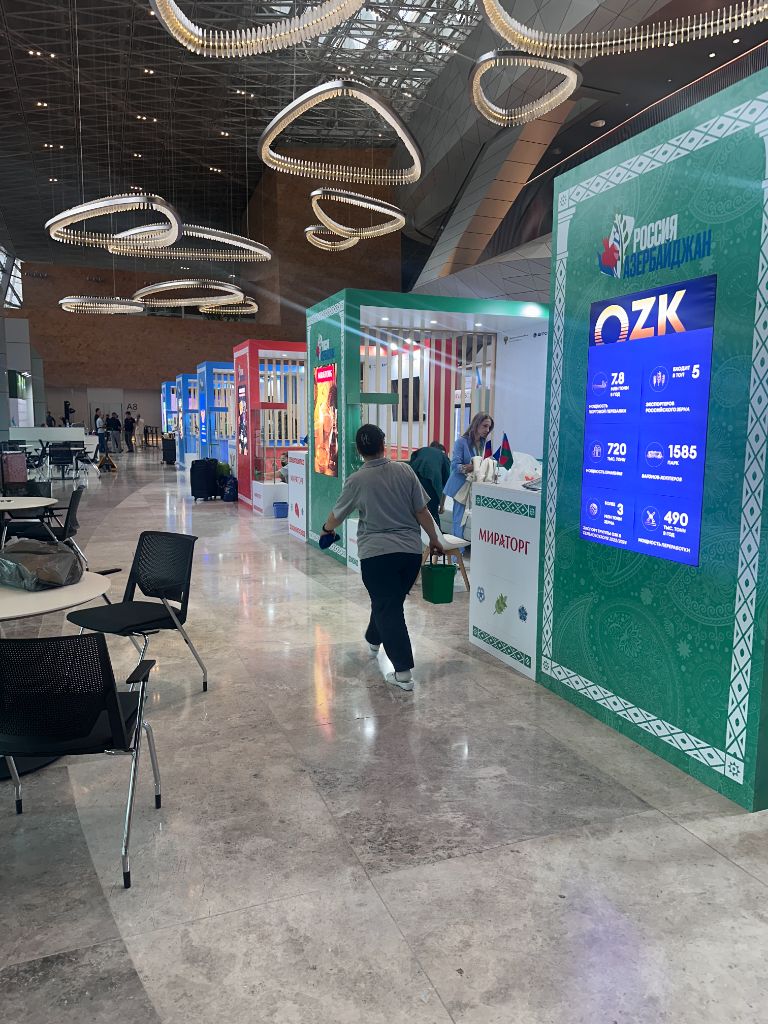 OZK pavilion — green exhibition stand with LED stats screen